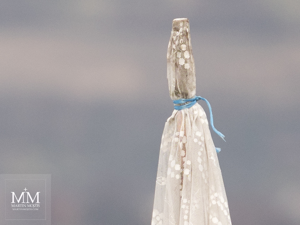 An old curtain attached with a blue string to a wooden rod. Photograph created with the Olympus M. Zuiko digital ED 40 - 150 mm 1:2.8 PRO.